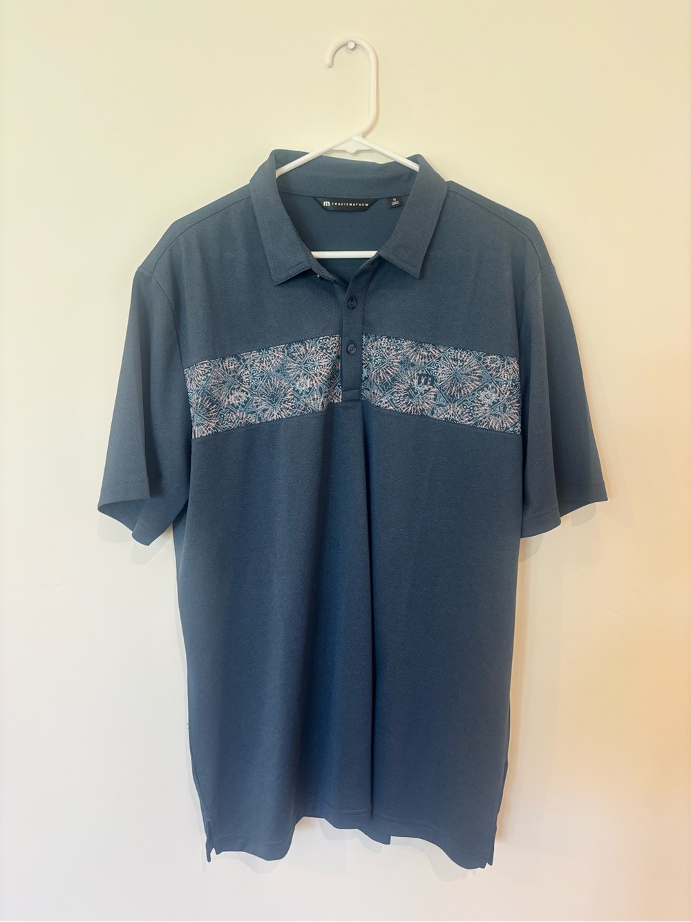 Travis Mathew Blue Polo with Floral Chest Band